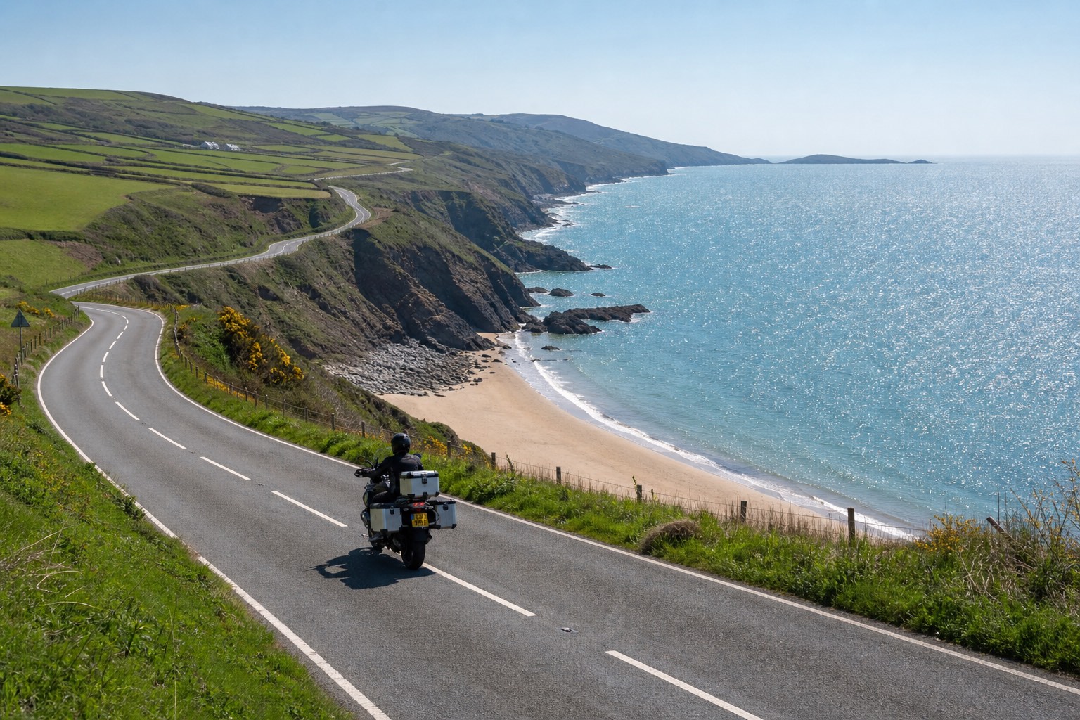 Motorcycle on a coastal road above a Welsh beach